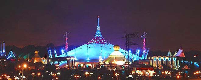 designer pool covers An amusement park aglow at night, with vibrant pool covers reflecting the colorful lights.