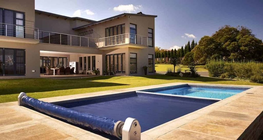 designer pool covers A house with a swimming pool fitted with a pool cover.